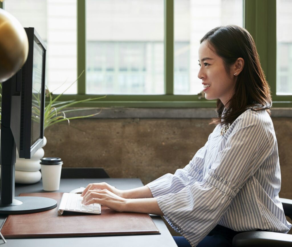 Chinese woman working at a computer in an office, side view